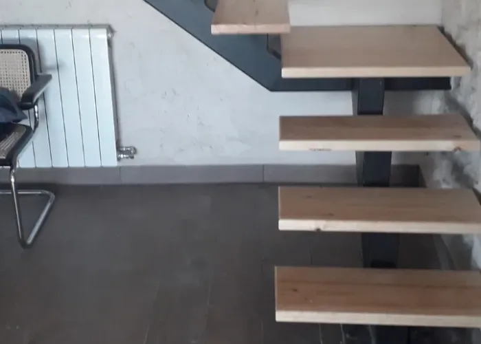 Escalera interior moderna con estructura metálica y peldaños de madera maciza, fabricada a medida por Carpintería Metálica Toni en San Pedro, Albacete. Diseño minimalista ideal para viviendas contemporáneas.