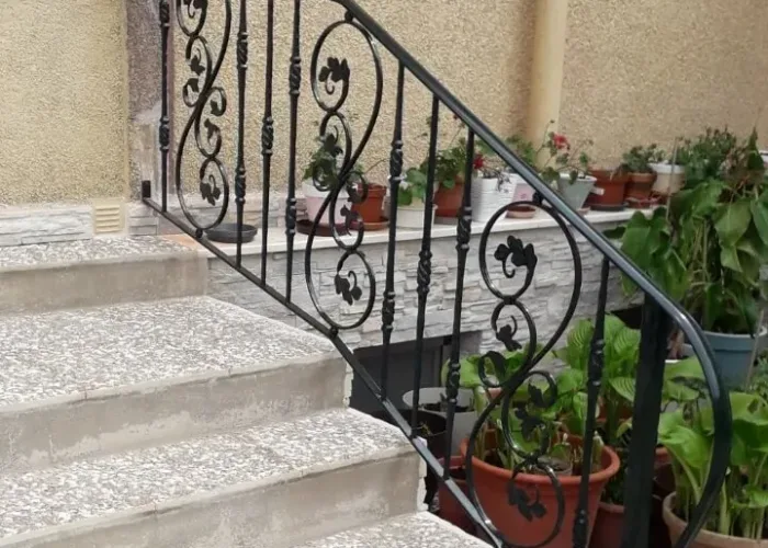 Barandilla de escalera exterior en hierro forjado con diseño ornamental, fabricada e instalada por Carpintería Metálica Toni en San Pedro, Albacete.