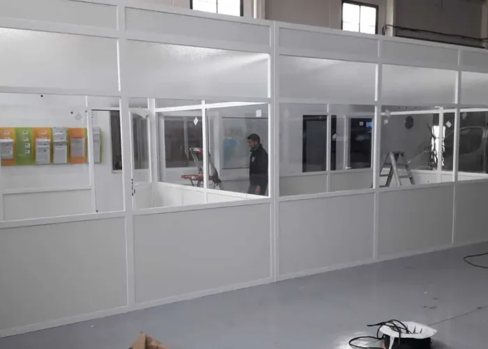 Oficina modular acristalada con estructura de aluminio blanco, instalada en nave industrial por Carpintería Metálica Toni en San Pedro, Albacete