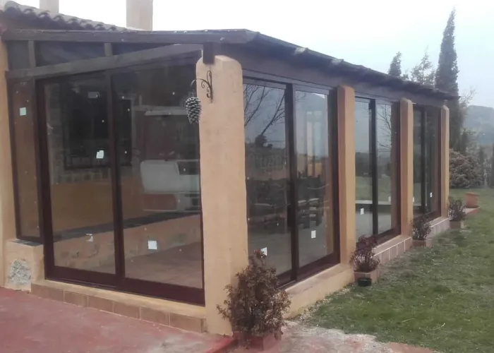 Cerramiento de terraza con estructura de aluminio marrón y cristales correderos, realizado por Carpintería Metálica Toni en San Pedro, Albacete