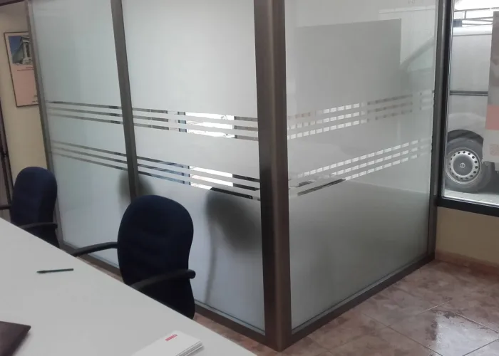 Cerramiento de oficina con perfilería de aluminio y vidrio mateado con vinilo decorativo, fabricado por Carpintería Metálica Toni en San Pedro, Albacete