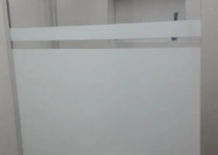 Mampara fija de ducha con franja central arenada para mayor privacidad y grifería de acero inoxidable. Instalación de plato de ducha pendiente de acabado, fabricado por Carpintería Metálica Toni en San Pedro, Albacete.