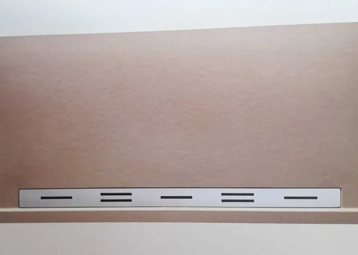 Plato de ducha rectangular en color beige con textura antideslizante y rejilla metálica lineal, fabricado a medida por Carpintería Metálica Toni en San Pedro, Albacete.