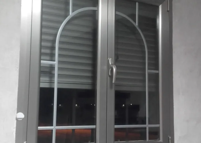 Ventana de aluminio con acabado en gris antracita y cristal decorativo con travesaños curvos, instalada por Carpintería Metálica Toni en San Pedro (Albacete). Una solución elegante y funcional que combina aislamiento térmico, durabilidad y diseño contemporáneo. Ideal para interiores modernos con estilo.