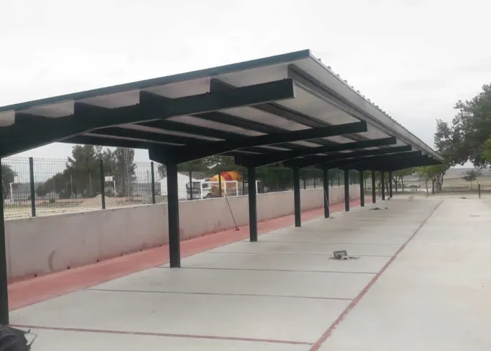 Cubierta metálica para zona de aparcamiento instalada por Carpintería Metálica Toni en San Pedro (Albacete). Un proyecto funcional y duradero que ofrece sombra y protección a los vehículos, con estructura de acero robusta ideal para espacios públicos o privados.