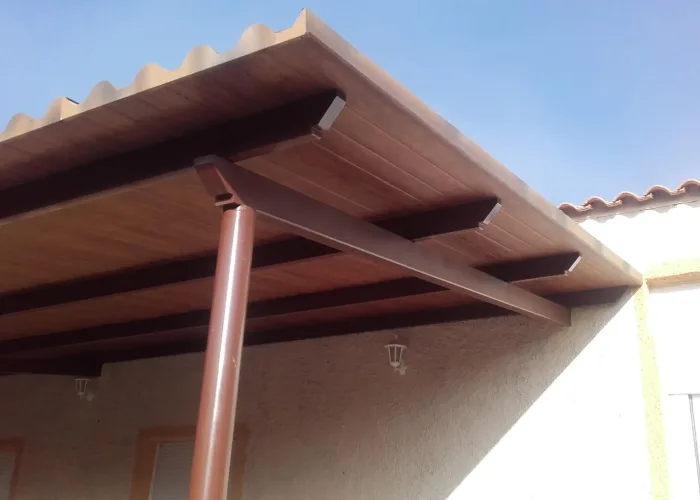 Techo para porche fabricado en panel sándwich con acabado imitación madera por Carpintería Metálica Toni en San Pedro, Albacete