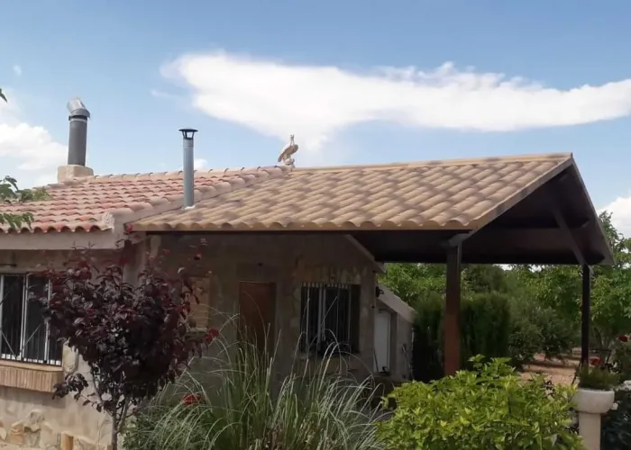 Porche metálico con cubierta de panel sándwich tipo teja instalado por Carpintería Metálica Toni en vivienda rural de San Pedro, Albacete. Estructura robusta y estética que combina con el tejado tradicional de la casa.
