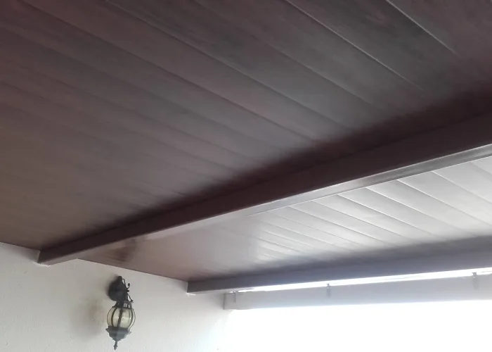 Detalle del techo de panel sándwich imitación madera instalado por Carpintería Metálica Toni en porche de vivienda en San Pedro, Albacete