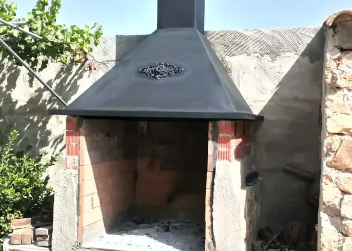 Campana metálica con chimenea para barbacoa de obra rústica, fabricada por Carpintería Metálica Toni en San Pedro, Albacete