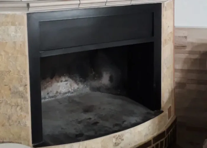 Chimenea de obra curva con embocadura metálica sin puerta, fabricada por Carpintería Metálica Toni en San Pedro, Albacete