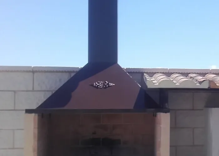 Campana metálica decorativa con chimenea para barbacoa de obra, fabricada por Carpintería Metálica Toni en San Pedro, Albacete