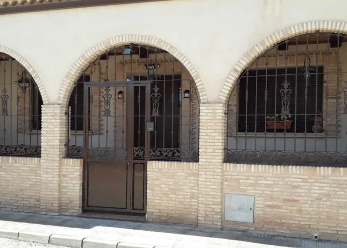Rejas de forja artesanal con diseño ornamental para porche y ventanas, fabricadas por Carpintería Metálica Toni en San Pedro (Albacete). Seguridad y estética tradicional en viviendas de estilo rústico.